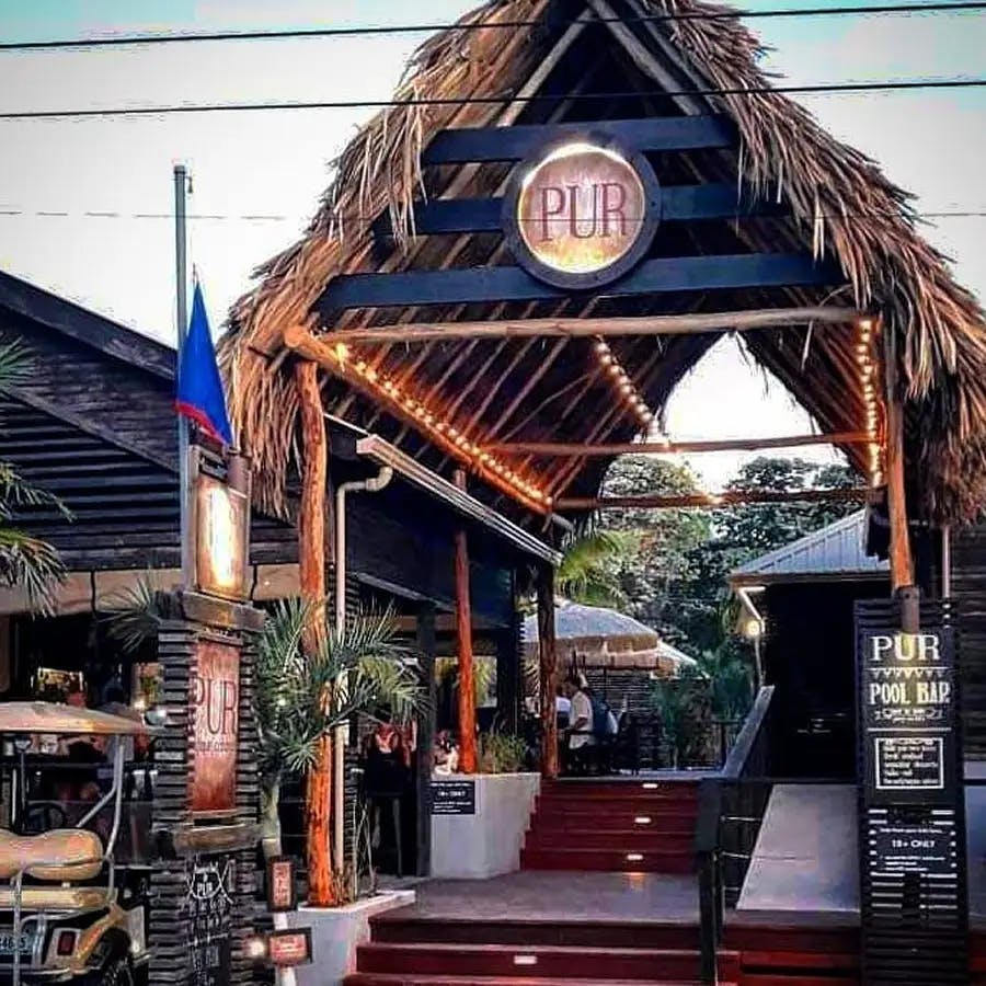 Grass roof, outdoor building, dining sign with menu and stairs into outdoor dining area